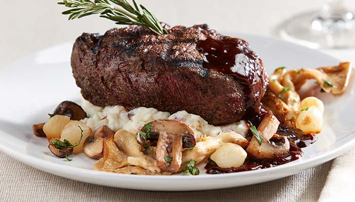 Grilled steak and mashed potatoes garnished with fried mushrooms served and catered at Waverly Beach Bar & Grille restaurant banquet venue in the Fox Valley Menasha, WI